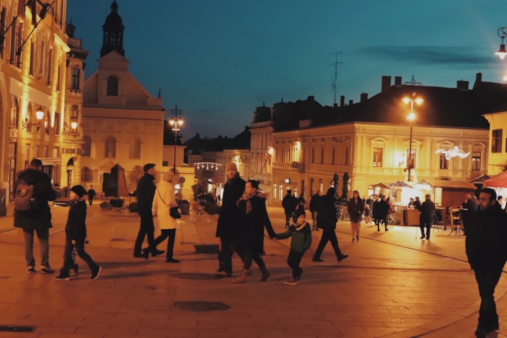 Piazza montenegrina illuminata di sera con persone che passeggiano