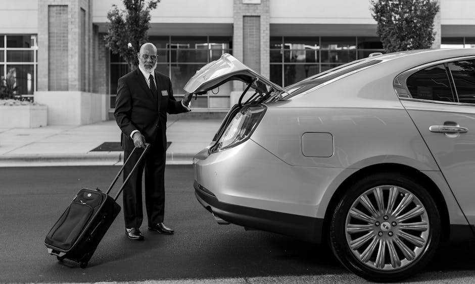 Grote koffer wordt in de kofferbak van een taxi geladen bij een hotel
