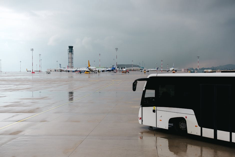 Airport apron with parked planes, control tower, and shuttle bus at Tivat Airport