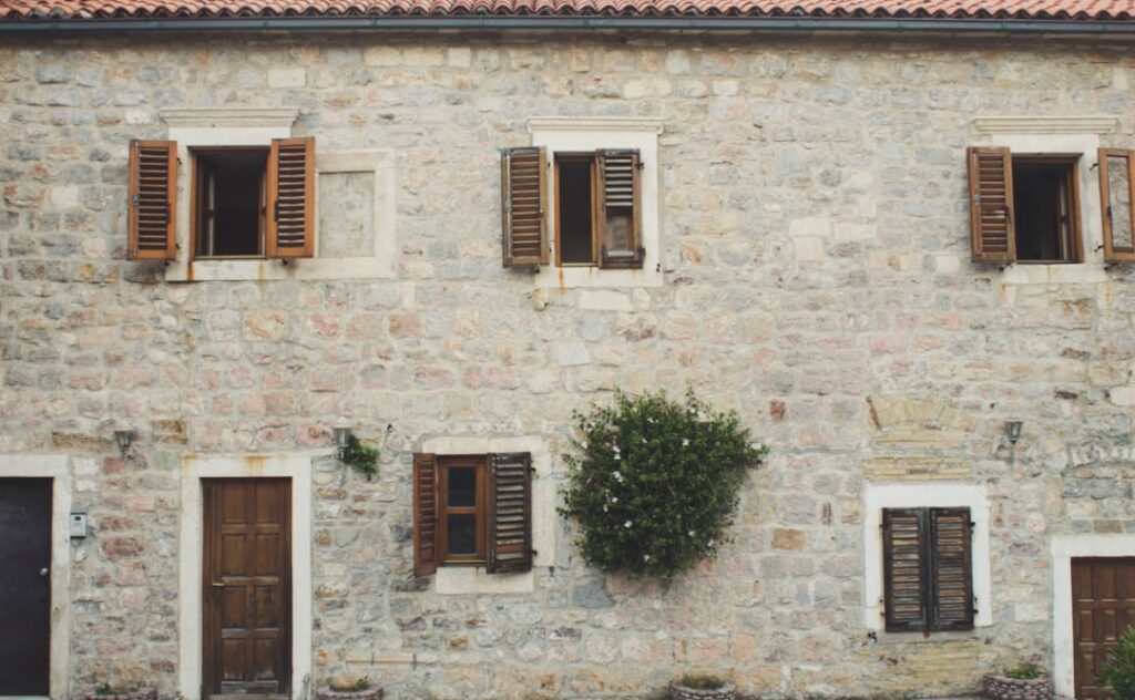 Old stone house facade with wooden shutters in Montenegro town