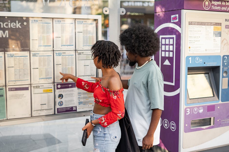 Two people checking bus timetable at a Montenegro bus stop kiosk