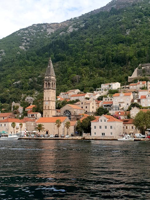 Church bell tower rising above coastal houses in Montenegro bay