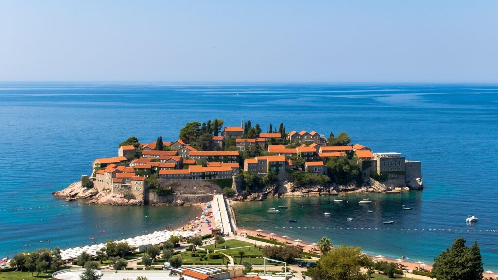 Seaside stone villa terrace with sunrise over Sveti Stefan islet