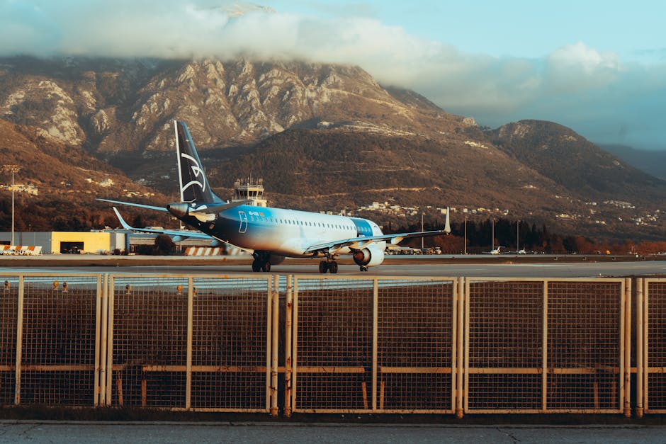 Aereo parcheggiato sulla pista con montagne dietro, aeroporto del Montenegro