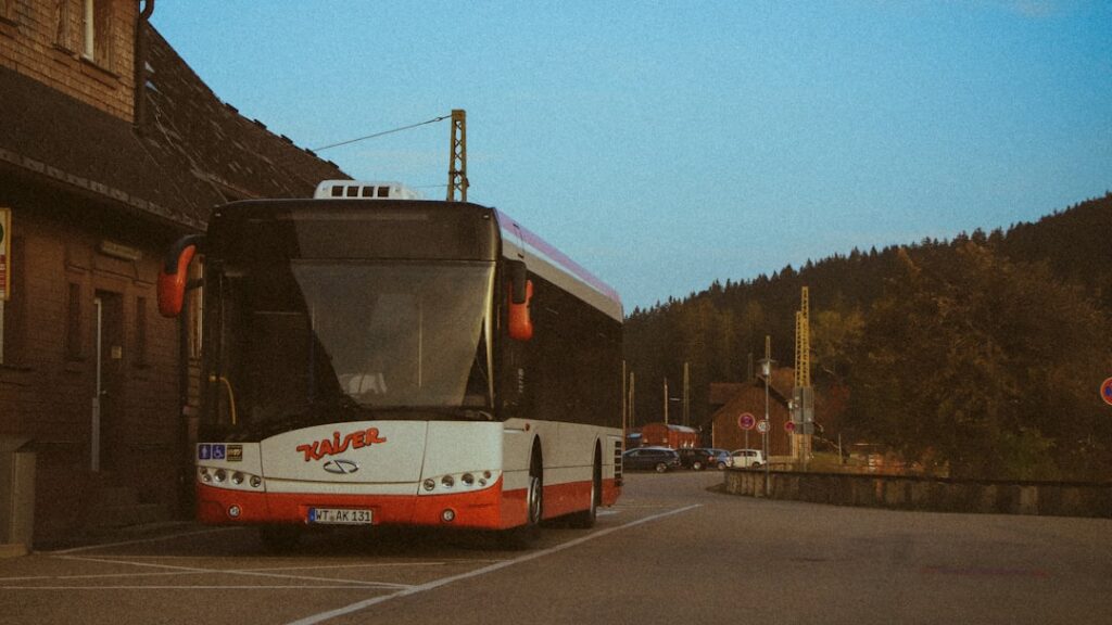 Autobus turistico bianco e rosso parcheggiato vicino alla stazione