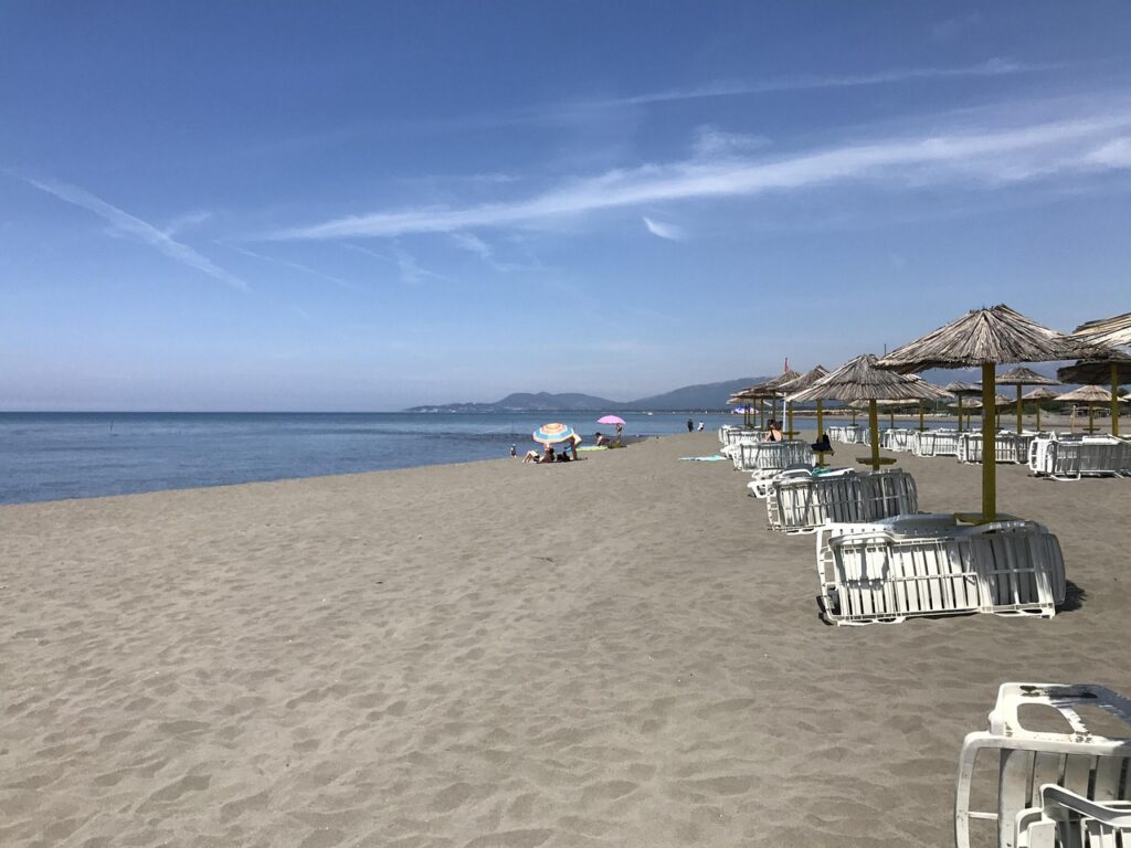 Leere Strandliegen und Sonnenschirme am ruhigen Sandstrand von Ulcinj