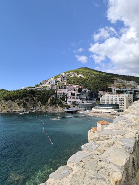 Baia con acque turchesi e edifici sulla collina a Budva, Montenegro