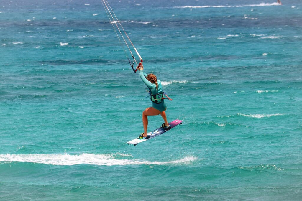 Kitesurferin springt über türkisblaues Meer vor Ulcinj, Montenegro