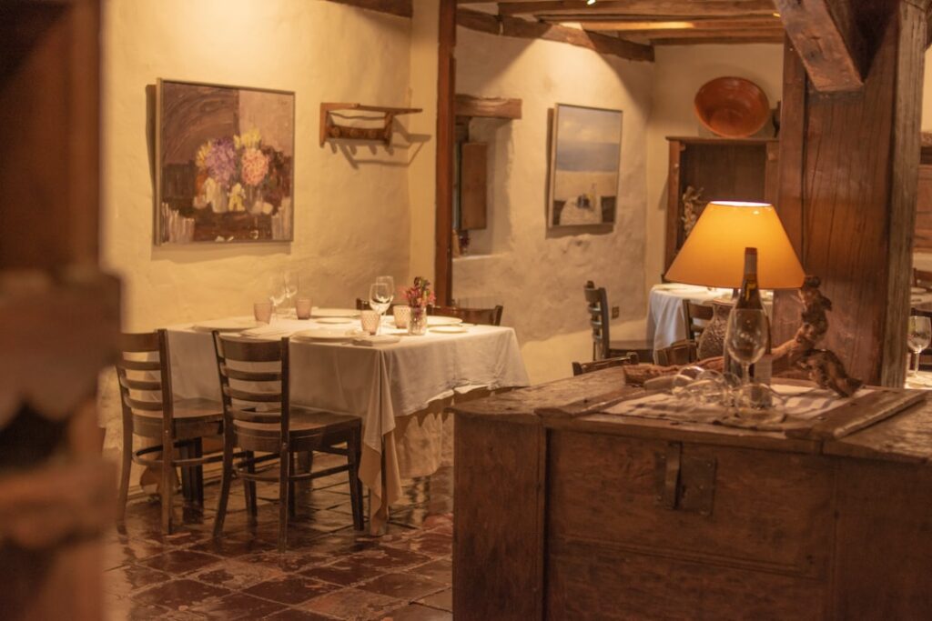 Gemütliches rustikales Restaurantinterieur mit gedeckten Tischen in Kotor, Montenegro