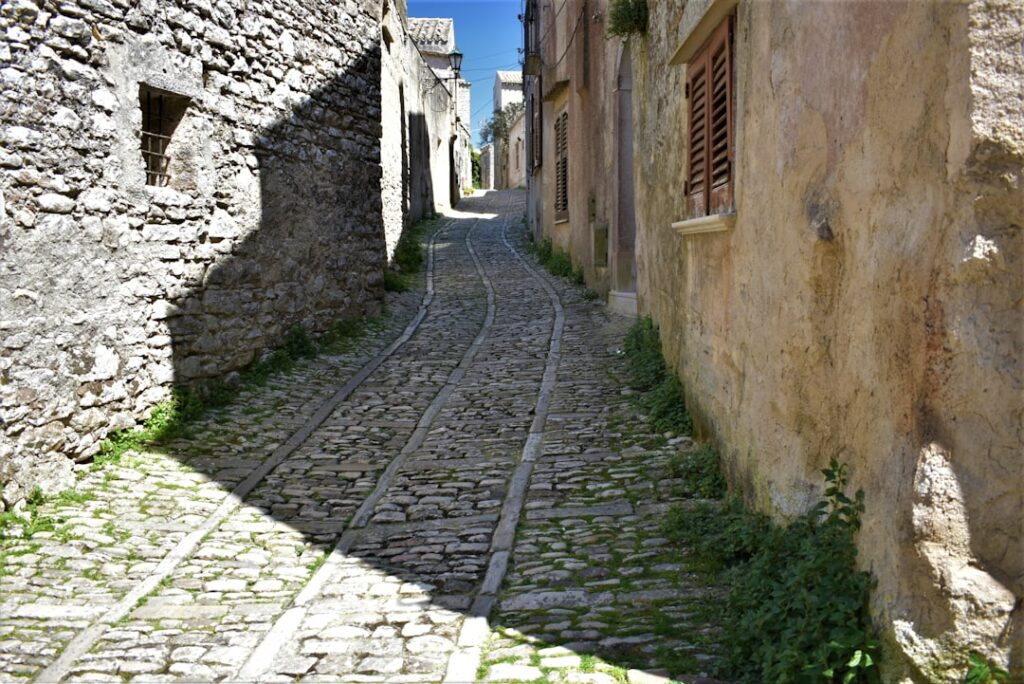 Schmale Kopfsteinpflastergasse zwischen alten Steinmauern in Kotor, Montenegro