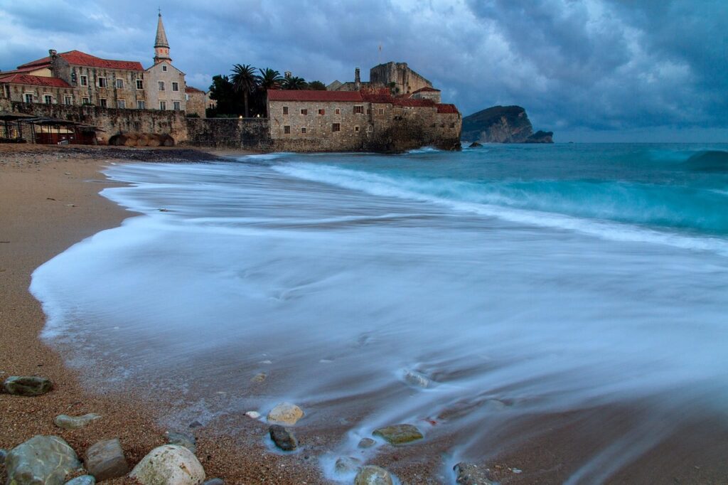 Onde accarezzano la riva davanti alle mura antiche di Budva, Montenegro