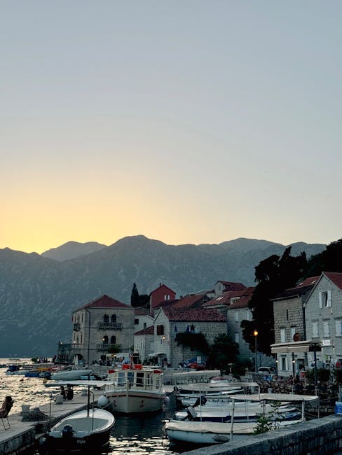 Abendlicher Hafen mit Booten vor Bergen in der Bucht von Kotor, Montenegro