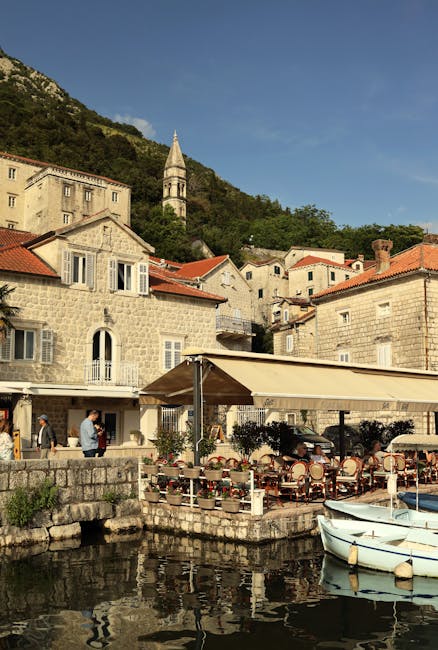 Lungomare con tavoli all'aperto e barche al porto di Perast, Montenegro