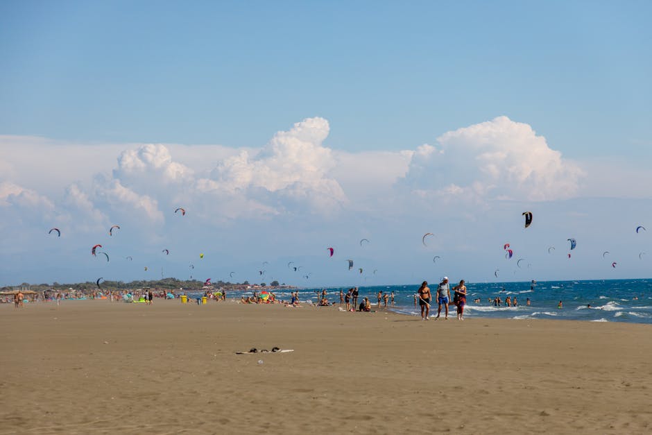 Breiter Sandstrand mit Kitesurfern und Badegästen in Ulcinj, Montenegro