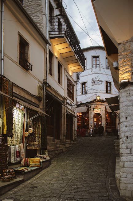 Vicolo acciottolato del centro storico con negozi, atmosfera serale in Albania