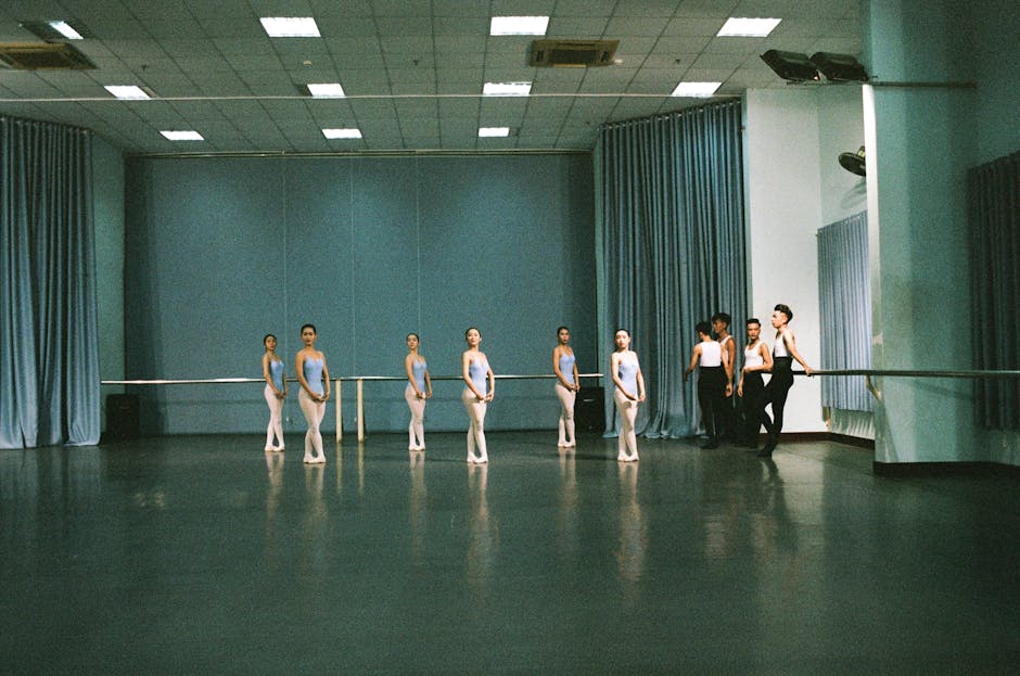Jeunes danseuses au repos près de la barre dans un grand studio
