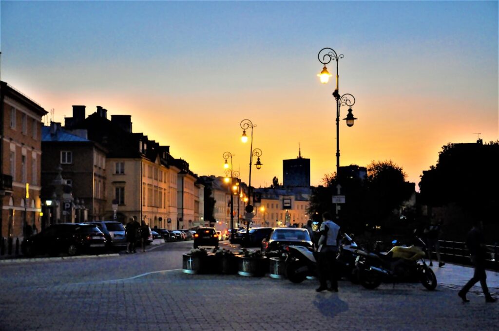 Sunset street with lit lampposts and parked motorcycles in Albania