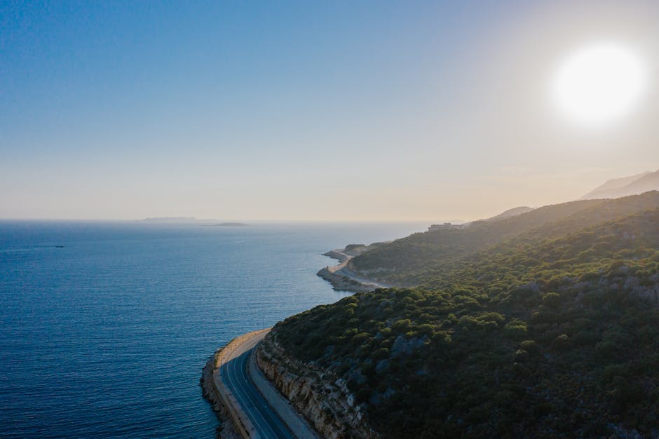 Route côtière sinueuse le long de falaises au coucher du soleil en Albanie