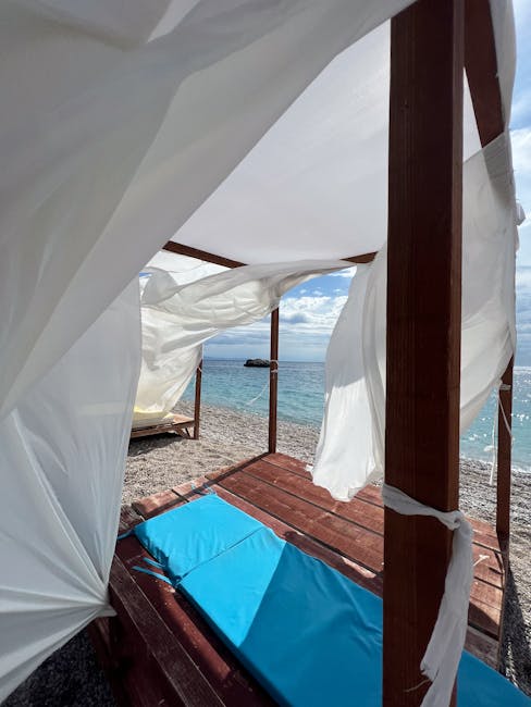 Cabane de plage avec voiles blanches et matelas bleu en Albanie