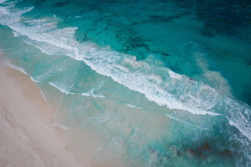 Vagues turquoise et sable fin sur une plage albanaise vue aérienne
