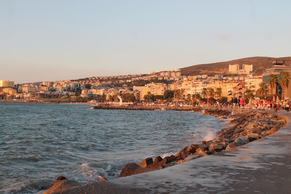 Front de mer avec digue rocheuse et bâtiments ensoleillés en Albanie