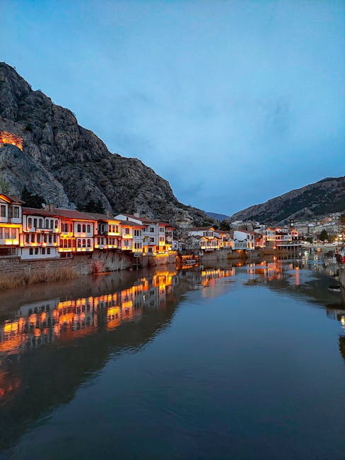 Maisons ottomanes éclairées le long d'une rivière, reflet nocturne en Albanie