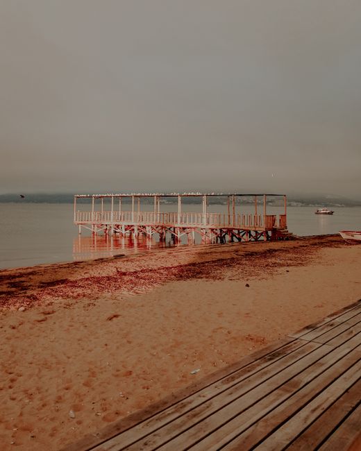 Jetée en bois sur une mer calme au crépuscule sur la côte albanaise