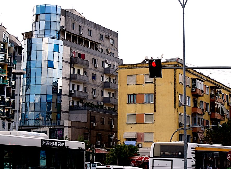 Bâtiments résidentiels et tour en verre, bus arrêtés sous feu rouge, Albanie