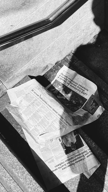 Journal froissé sur des marches en pierre, ombres contrastées
