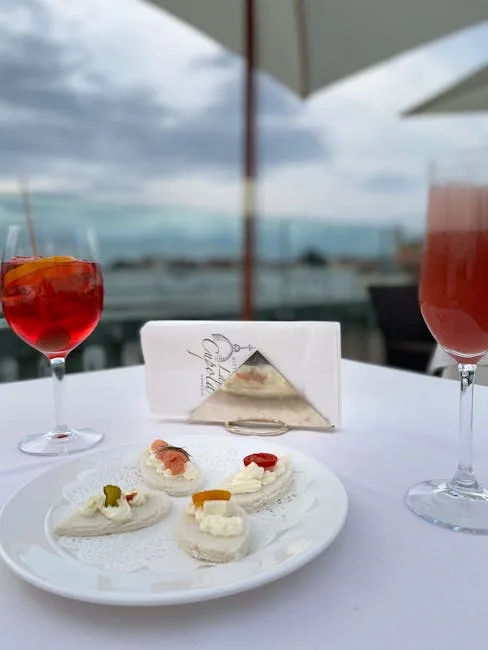 Terrasse vénitienne avec spritz et petites bouchées, vue floue sur la lagune.