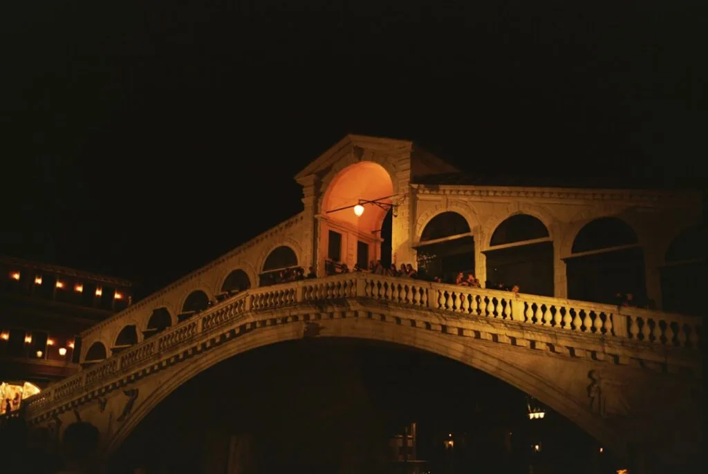 Pont du Rialto illuminé la nuit, balustrade animée à Venise