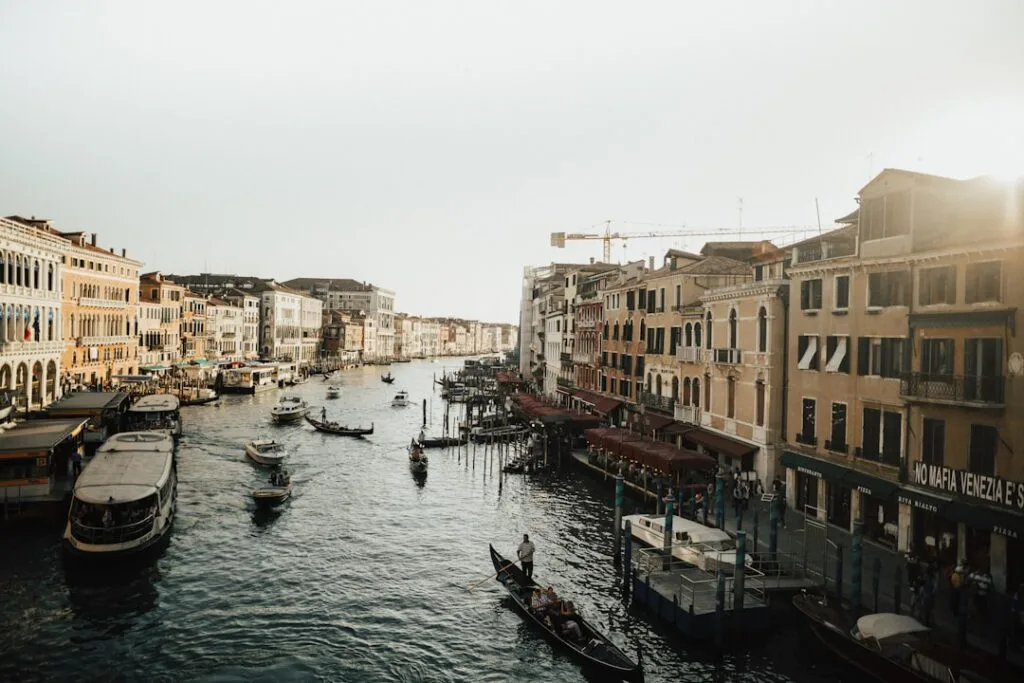 Le Grand Canal de Venise avec gondoles et bateaux sous le soleil.