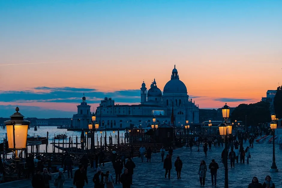 Silhouette de la basilique à Venise au coucher, lampadaires et passants.