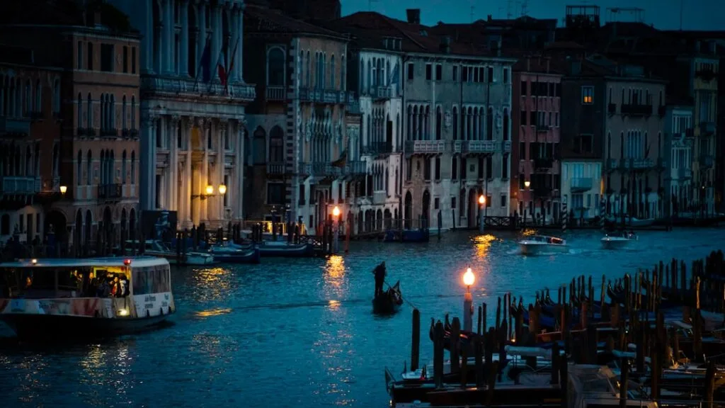 Vaporetto et gondole sur le Grand Canal au crépuscule à Venise