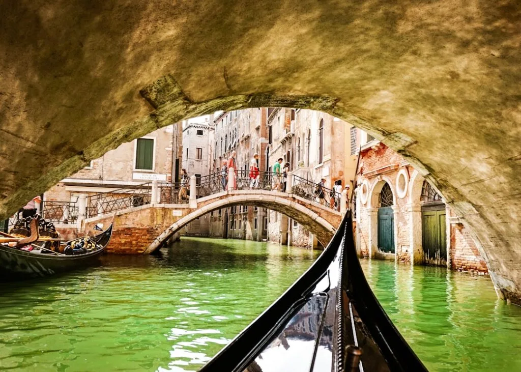 Gondole glissant sous un pont étroit dans un canal de Venise