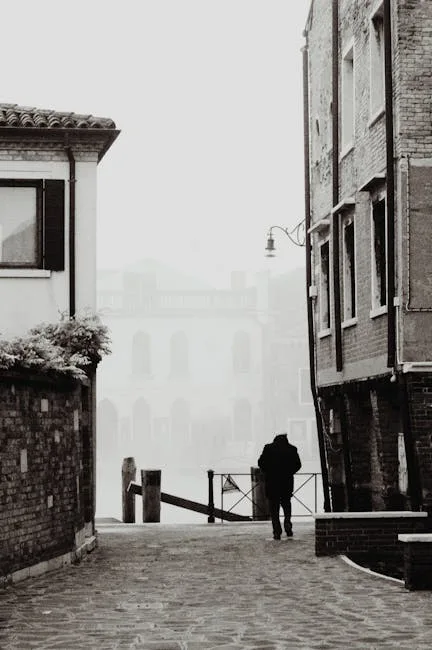 Promeneur solitaire dans une ruelle vénitienne, brume sur le canal.