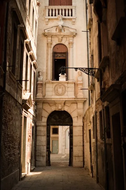 Ruelle étroite de Venise menant à une entrée ornée en pierre