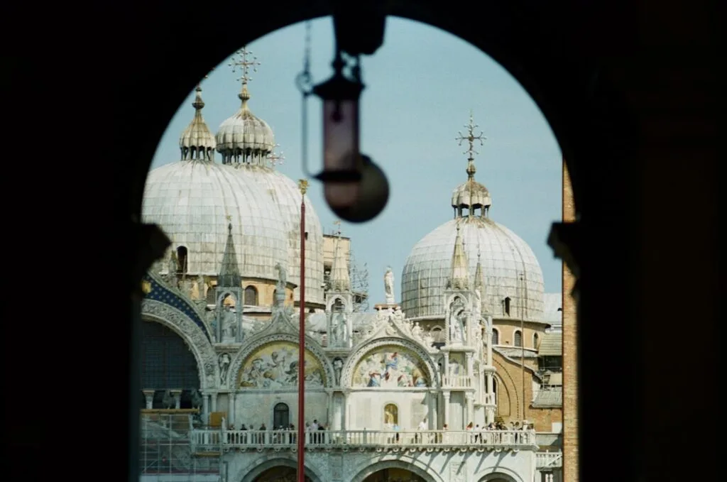 Dômes de la basilique Saint-Marc encadrés par une arche à Venise