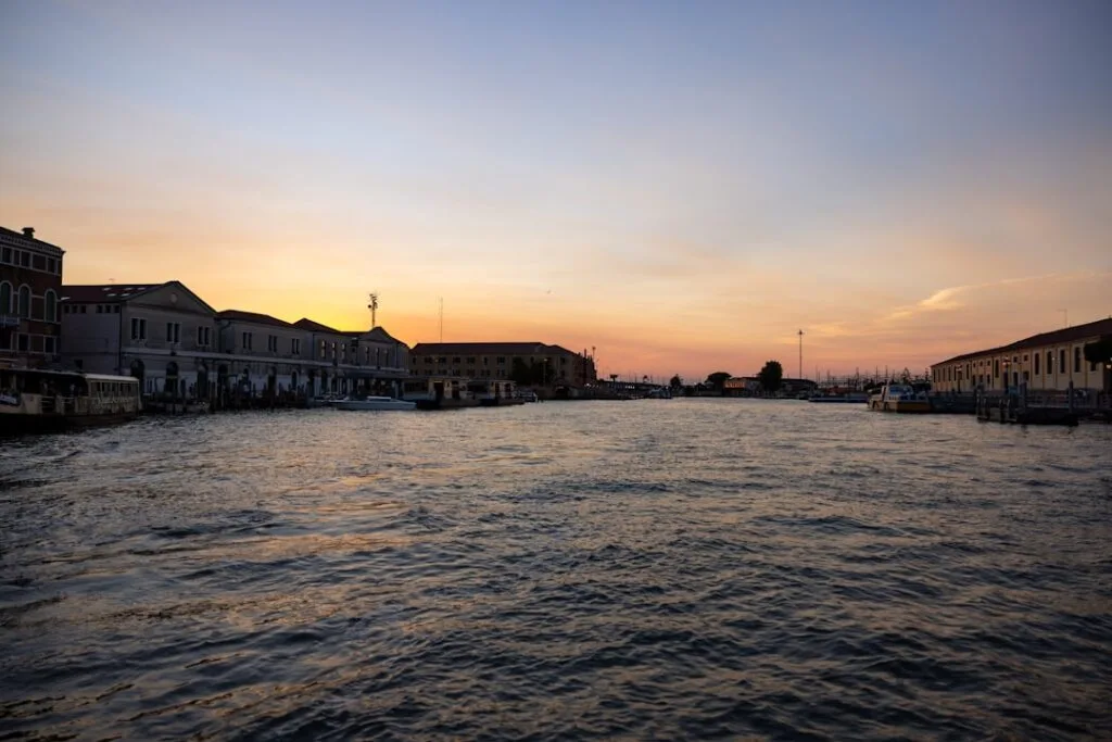 Canal principal de Venise au coucher du soleil, eaux calmes et bateaux