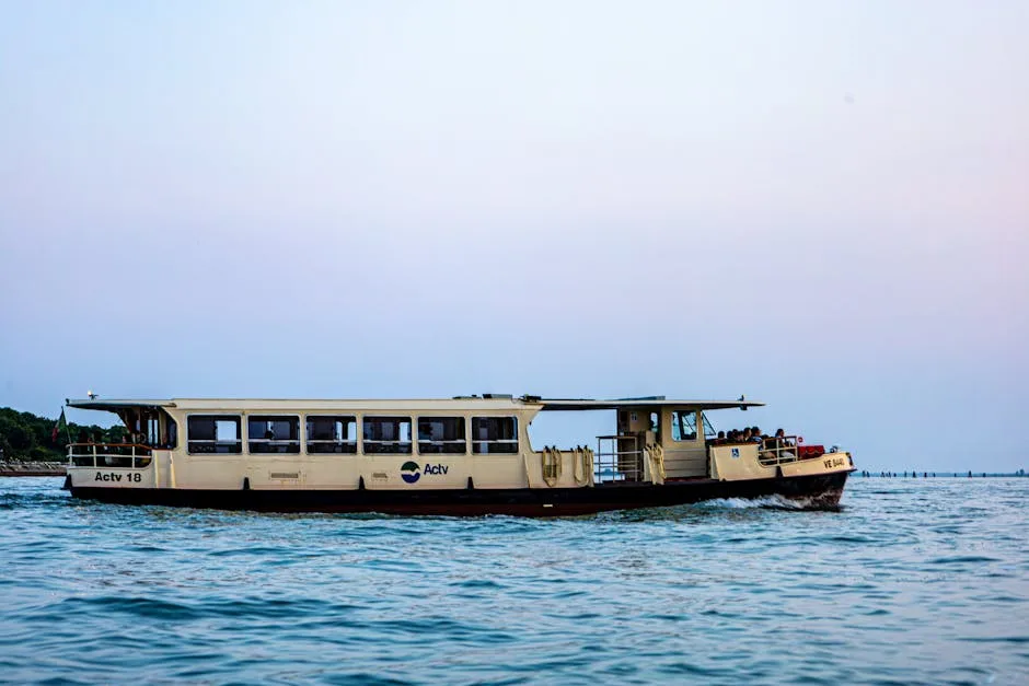 Vaporetto Actv naviguant dans la lagune de Venise au crépuscule.