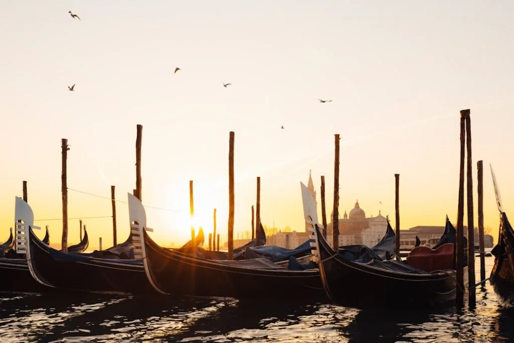 Gondoles alignées au lever du soleil sur la lagune de Venise