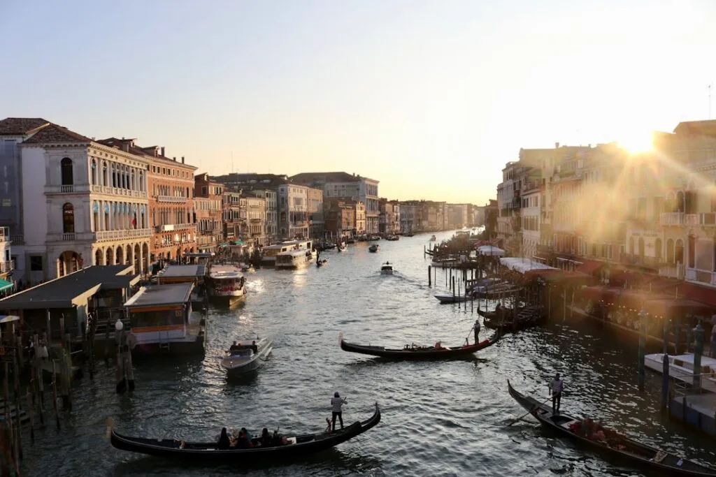 Gondoles et vaporetto sur le Grand Canal de Venise au coucher.