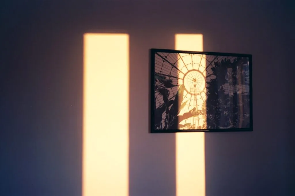 Deux bandes de lumière chaude projectées sur un mur avec un cadre