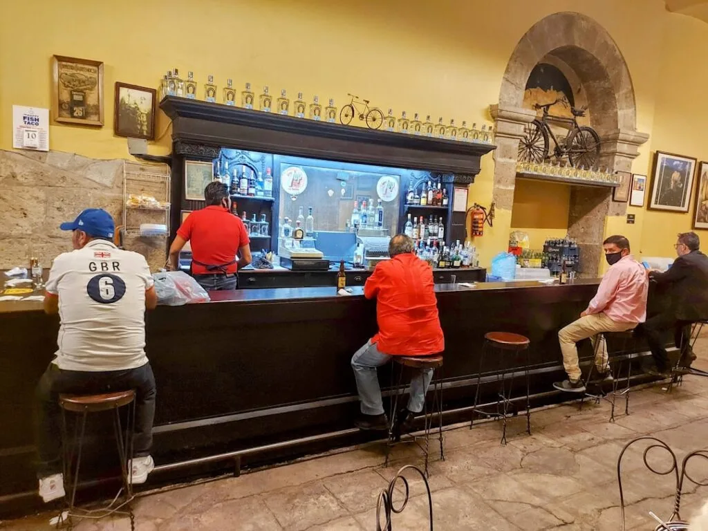 Clients assis au comptoir d'un bacaro traditionnel à Venise