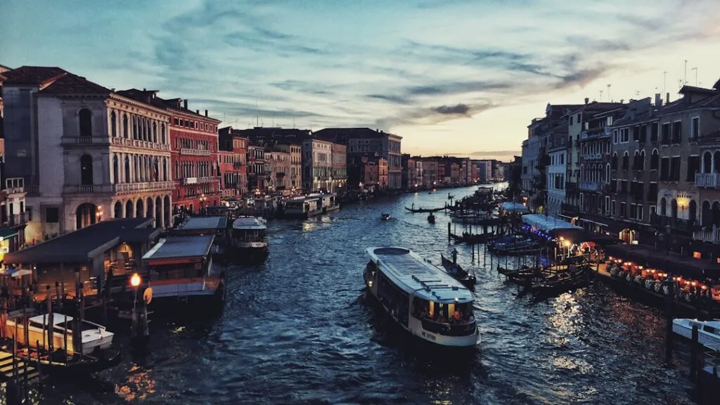 Canal animé au crépuscule avec vaporetto et gondoles, Venise