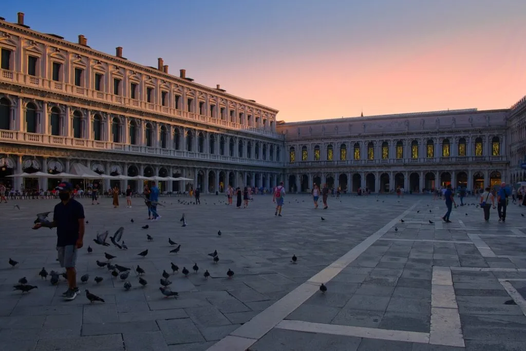 Place Saint-Marc à Venise au crépuscule, pigeons et arcades