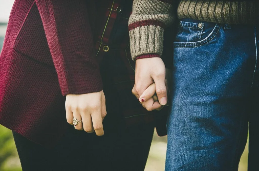 Gros plan de deux personnes se tenant la main, vêtements décontractés