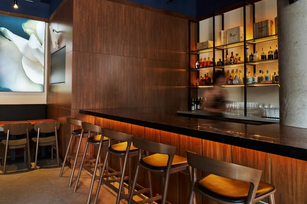 Bar élégant avec tabourets en bois et étagères à Venise