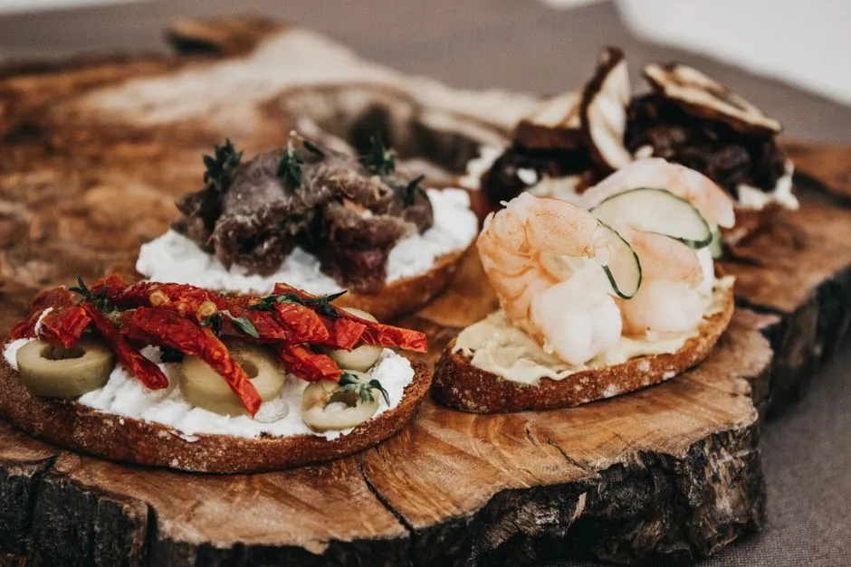 Tranches de pain garnies de cicchetti variés sur planche en bois, Venise