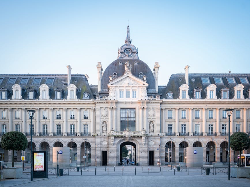 Ornate neoclassical facade with central arch and symmetrical windows.